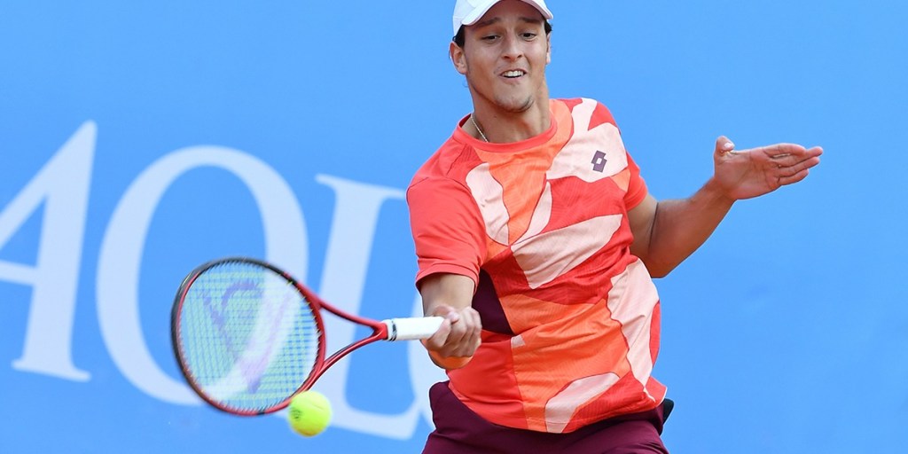 Luciano Darderi durante un incontro del circuito ATP con la maglia da gioco, concentrato durante uno scambio in campo.